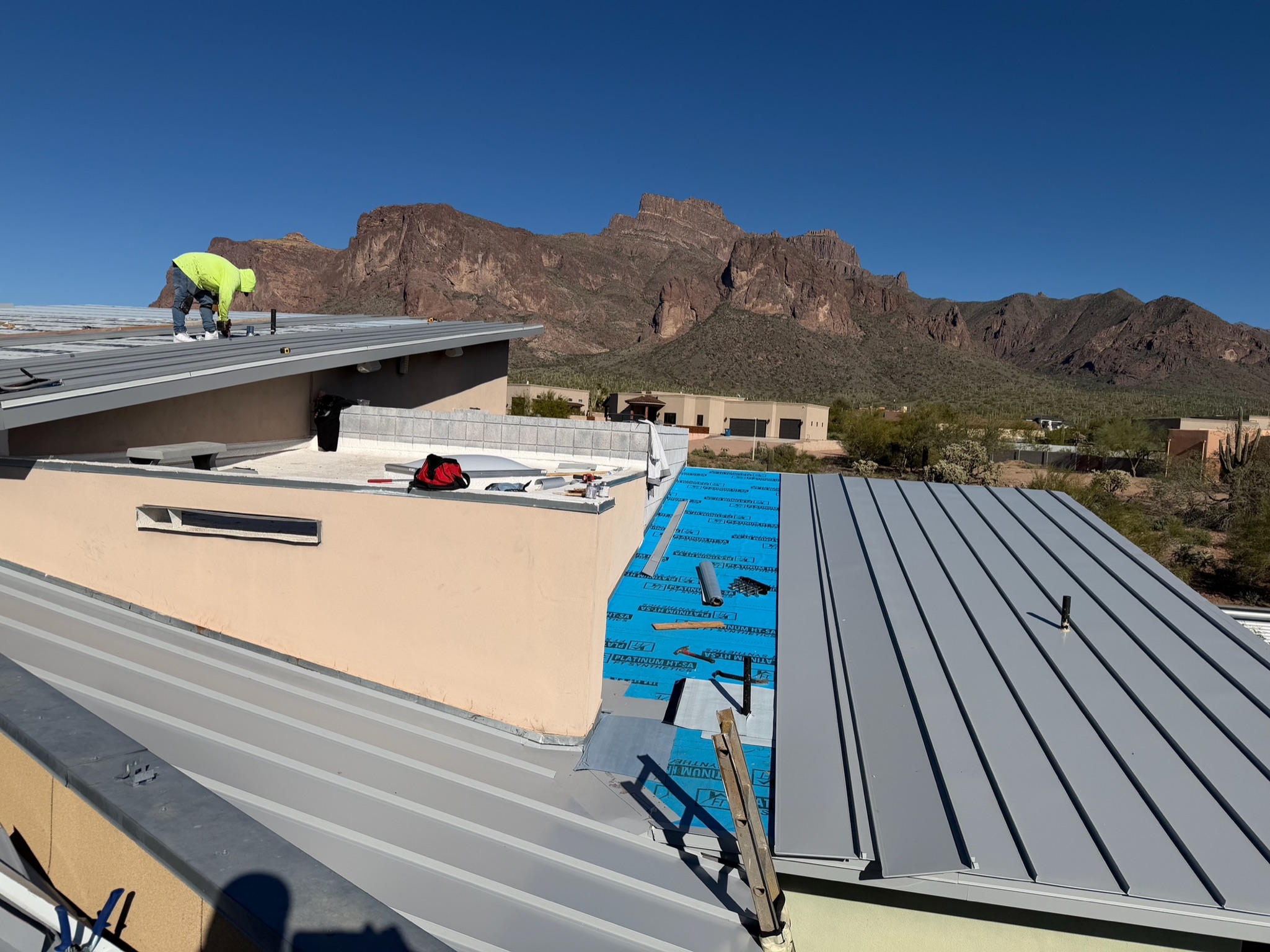 Standing seam metal roof installation with Arizona mountains